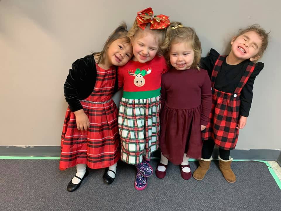Group of four girls smiling at daycare | Pleasant Day Schools